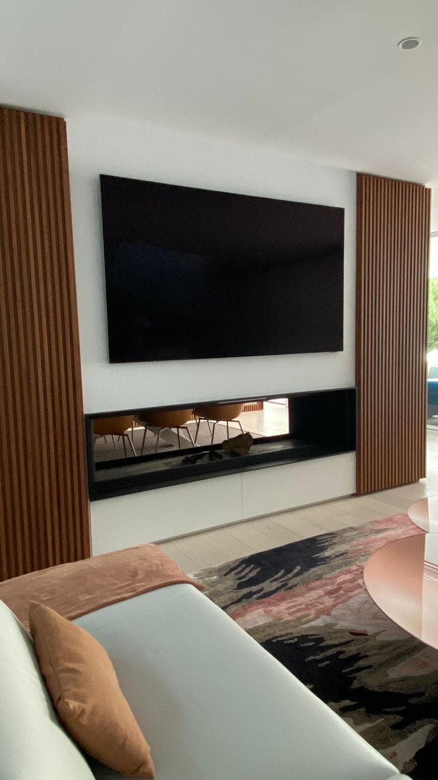 Chimenea a medida: doble cara entre listones de madera (Barcelona)