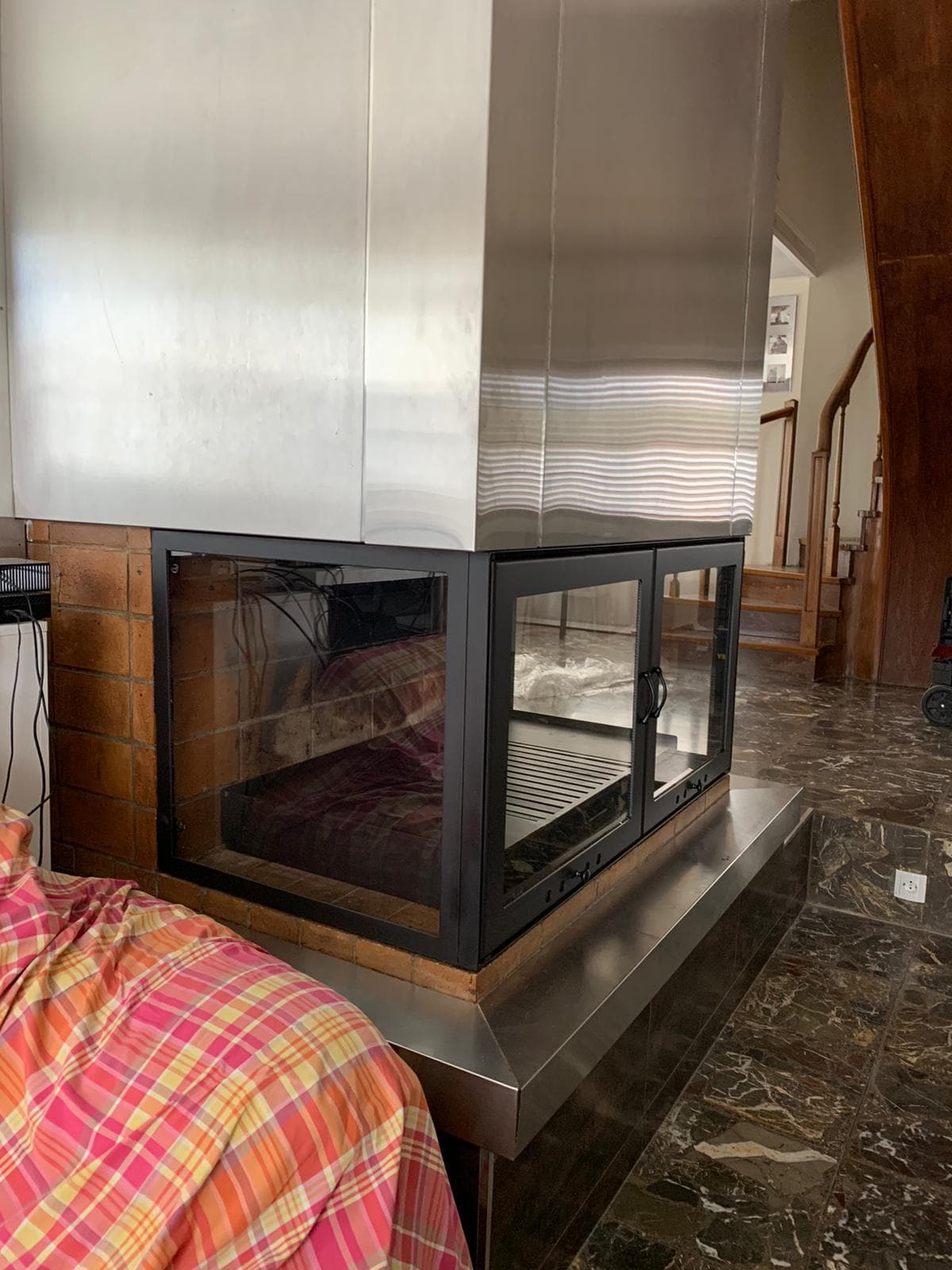 Cerramiento de cristal hecho a medida para una chimenea de leña, con cristal en el frente y en el lateral