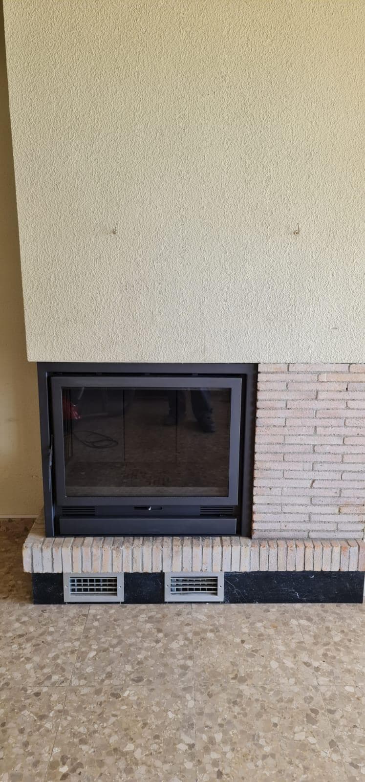La misma chimenea cerrada con un cerramiento a medida con puerta de cristal