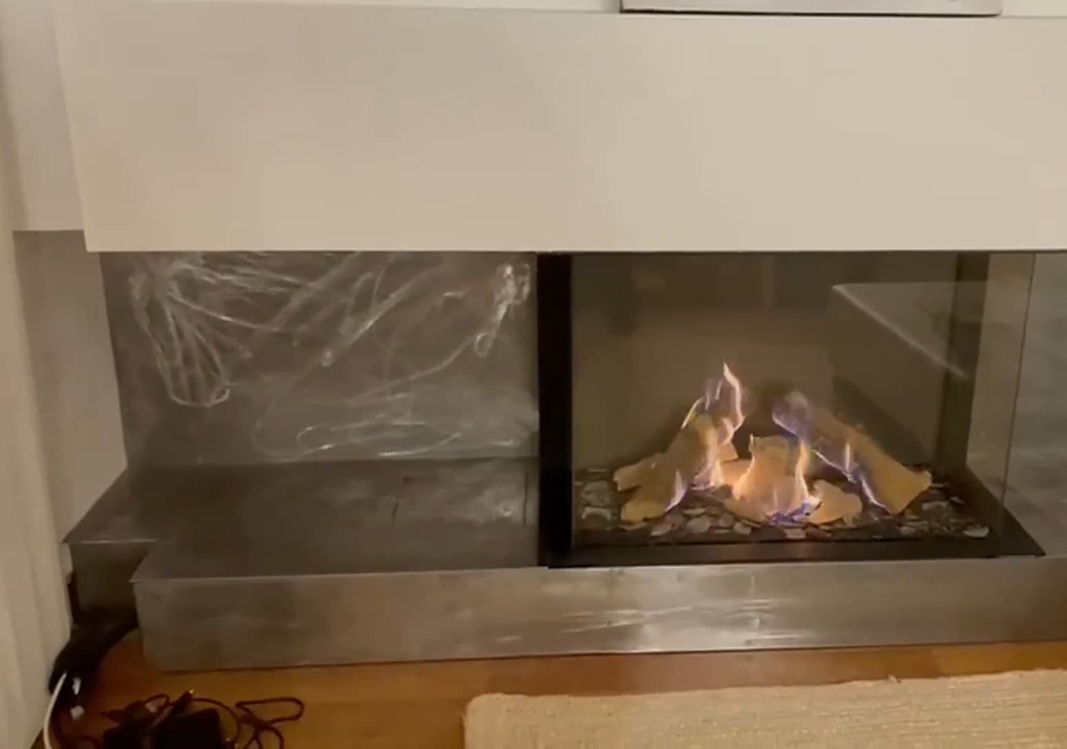 Llama de gas tras el cristal de una chimenea estanca de tres caras con revestimiento metálico, en Premià de Mar