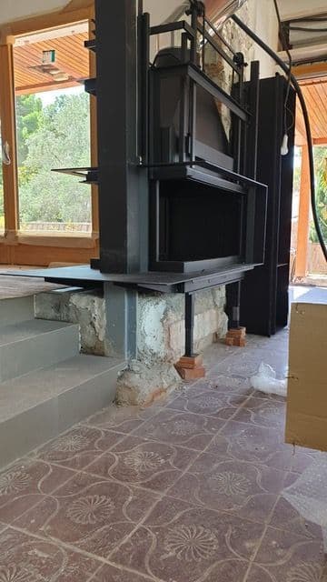 Chimenea de leña de tres caras en obra, con la estructura de acero antes del revestimiento