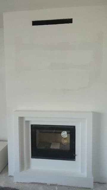 La misma chimenea con un casete de leña nuevo y un cerramiento de pladur blanco