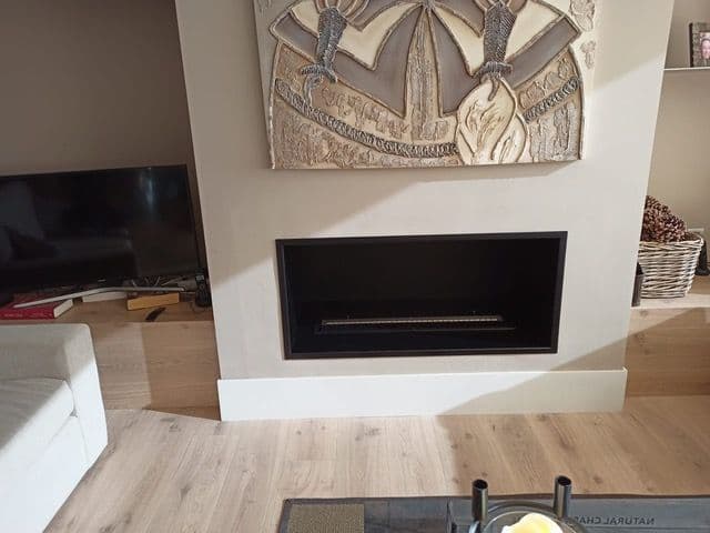 The same masonry fireplace refurbished with a black box and a linear bioethanol burner