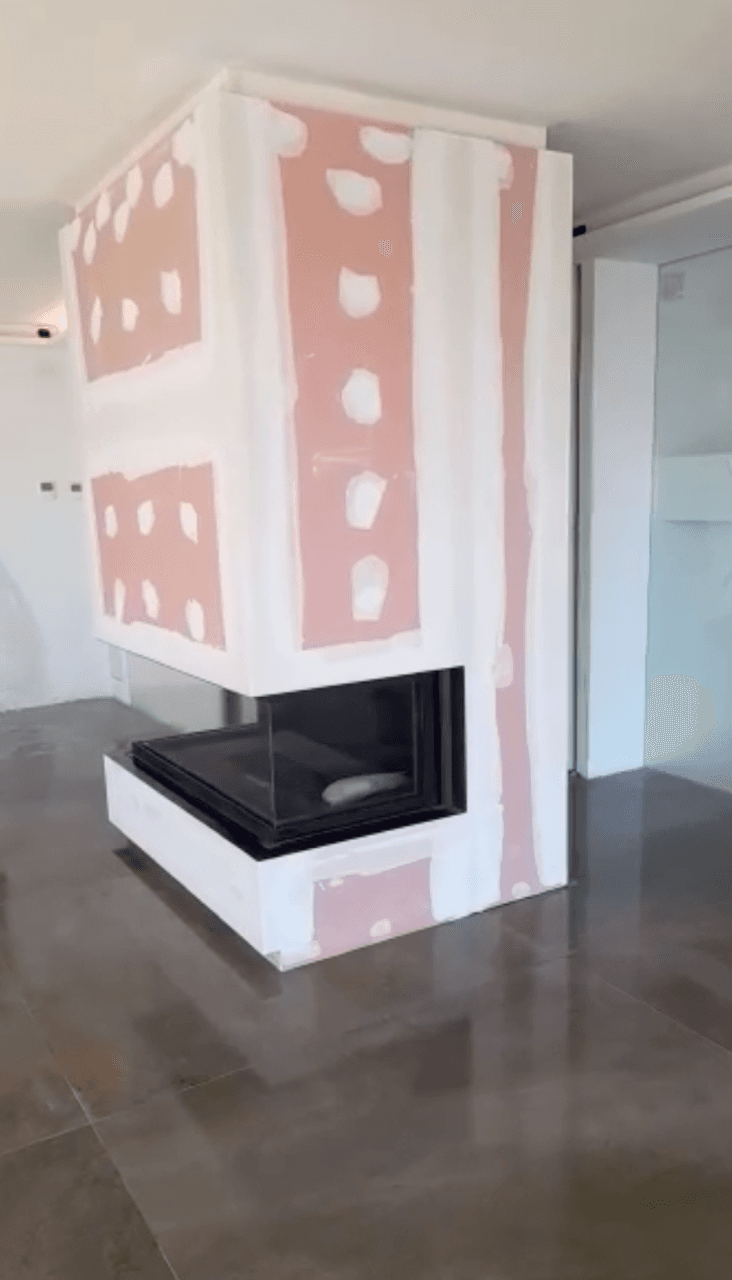 Chimenea de leña de tres caras con apertura en guillotina, en obra antes del revestimiento