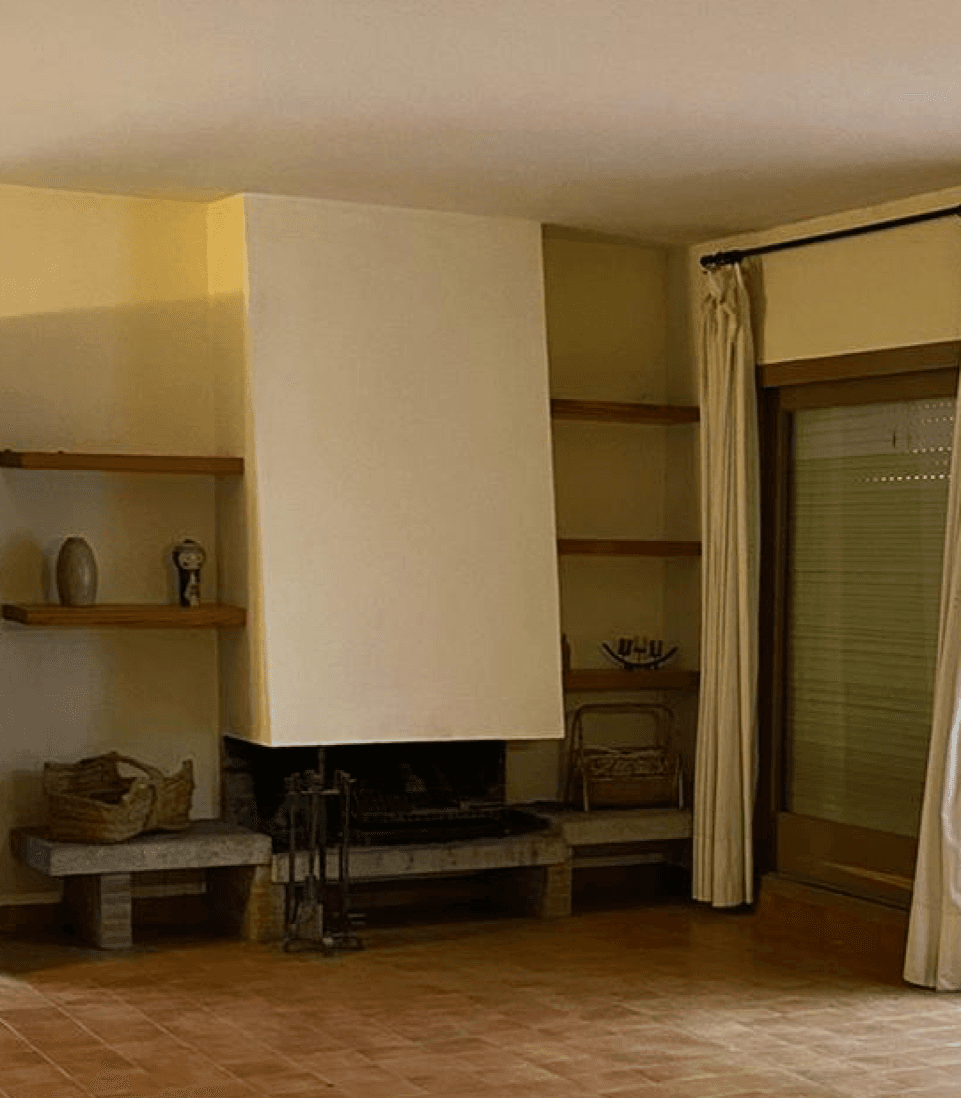 Chimenea de leña abierta con campana blanca y bancada de obra, antes de cerrarla con un cassette