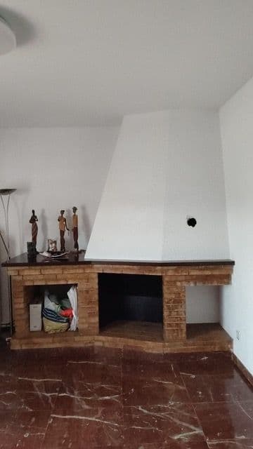 Chimenea de leña clásica de ladrillo en una esquina del salón, antes de la instalación