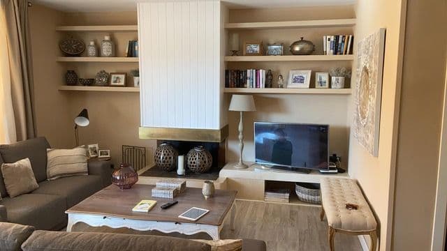 Salón con una chimenea de leña cerrada con un cerramiento de cristal hecho a medida